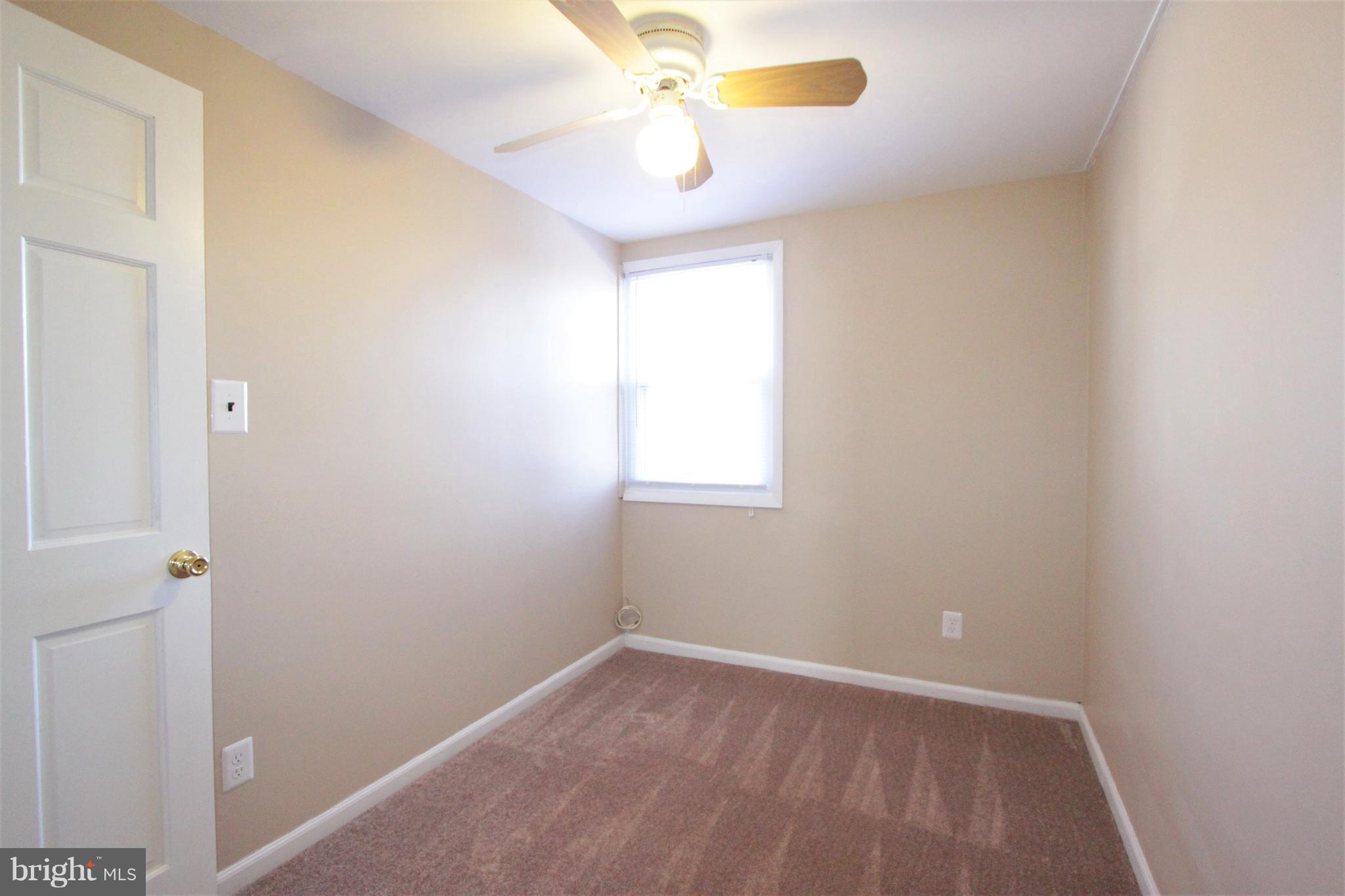 3111 Bero Road Baltimore, MD 21227 - Photo 10 of 25 an empty room with a window and a fan