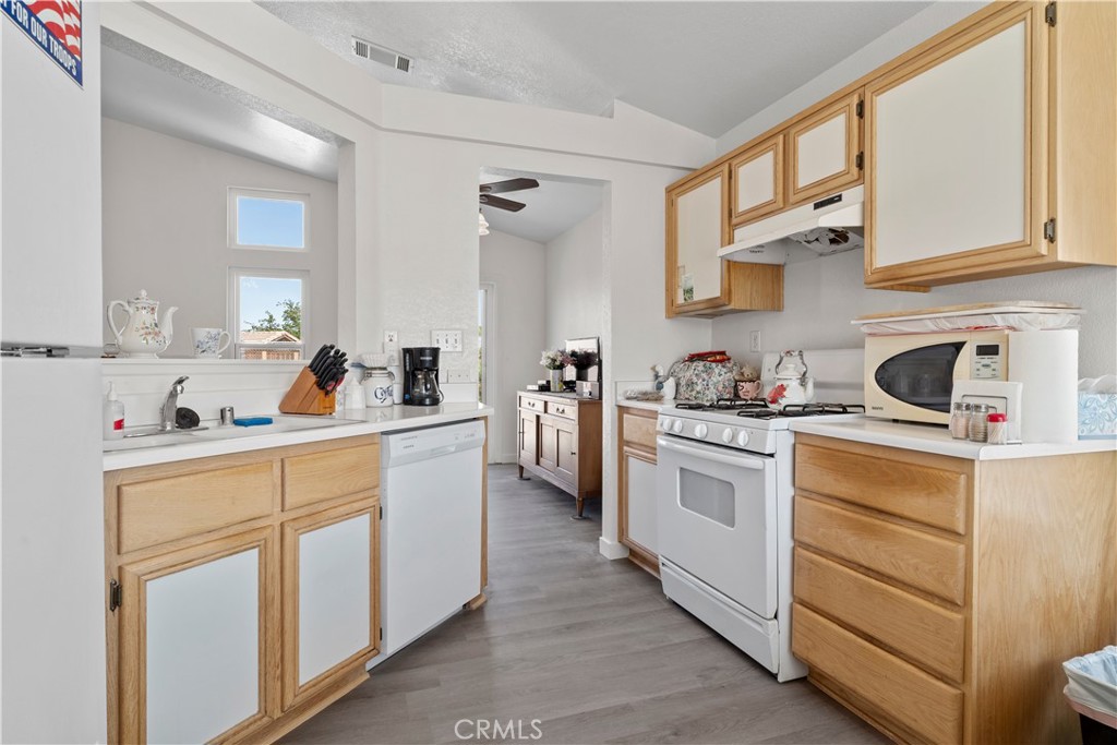 11688 Cornell Street Adelanto, CA 92301 - Photo 11 of 40 a kitchen with cabinets appliances a sink and a window