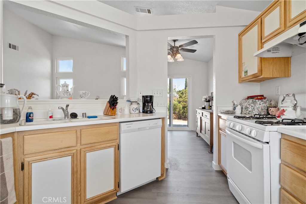 11688 Cornell Street Adelanto, CA 92301 - Photo 13 of 40 a kitchen with cabinets appliances a sink and a counter top space