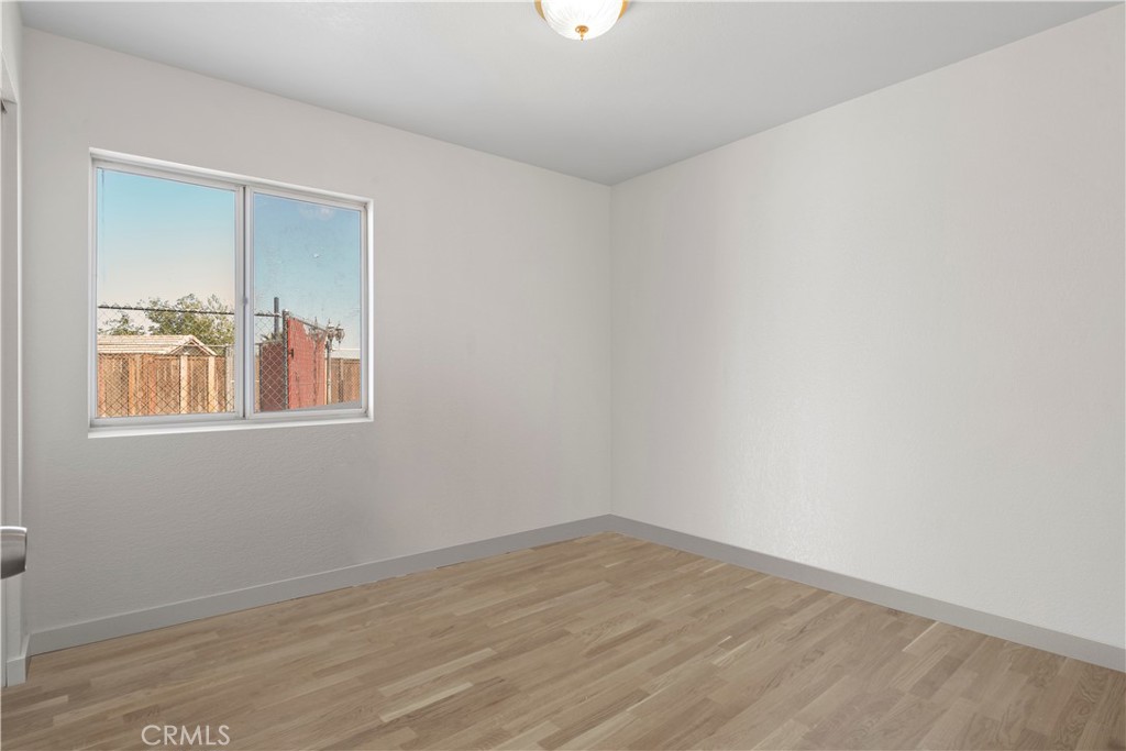 11688 Cornell Street Adelanto, CA 92301 - Photo 15 of 40 a view of an empty room with wooden floor and a window
