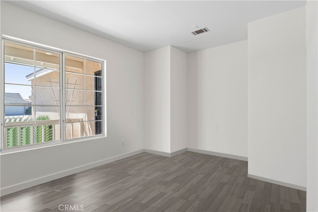 11688 Cornell Street Adelanto, CA 92301 - Photo 20 of 40 a view of an empty room with wooden floor and a window