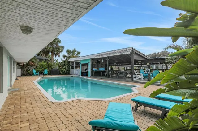 a kitchen with stainless steel appliances granite countertop a stove a sink dishwasher and a dining table with cabinets