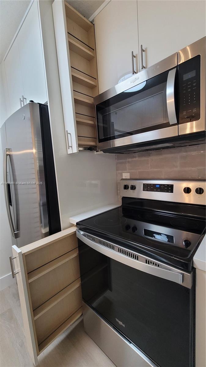 22731 Southwest 88th Place, Unit 101 Cutler Bay, FL 33190 - Photo 17 of 59 a stove top oven sitting inside of a kitchen