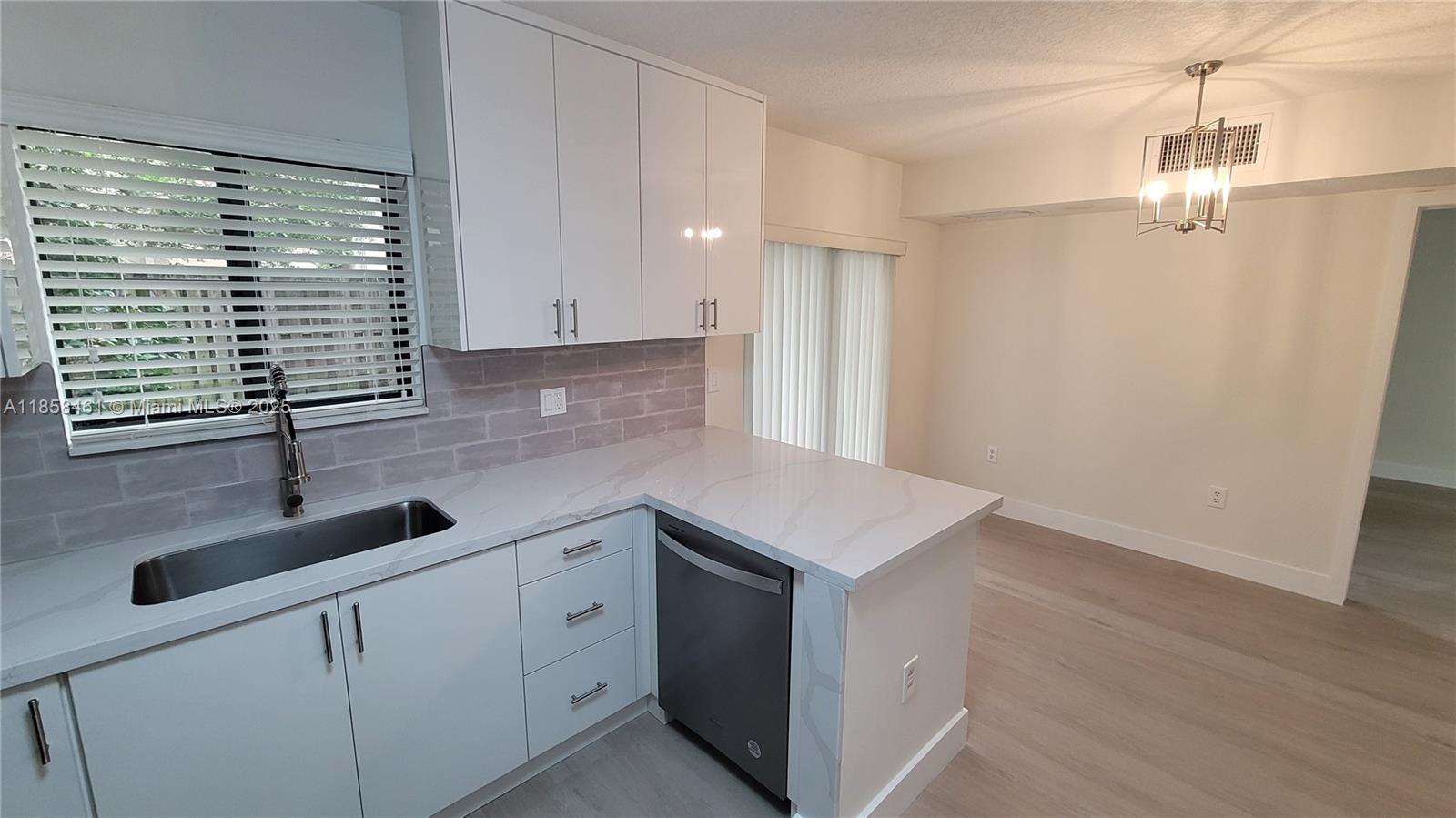 22731 Southwest 88th Place, Unit 101 Cutler Bay, FL 33190 - Photo 18 of 59 a kitchen with a sink and cabinets