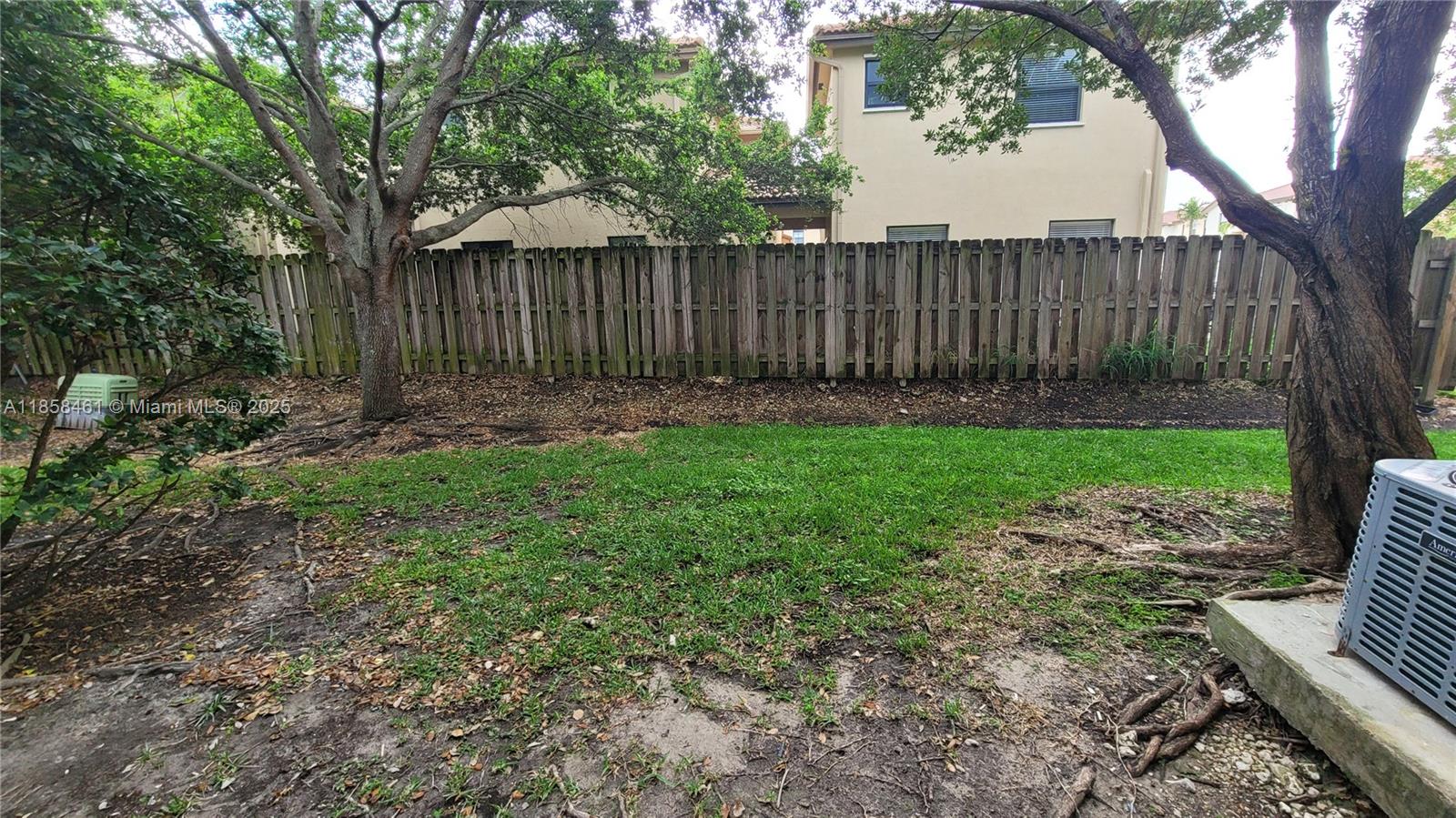 22731 Southwest 88th Place, Unit 101 Cutler Bay, FL 33190 - Photo 19 of 59 a view of backyard with wooden fence and a large tree