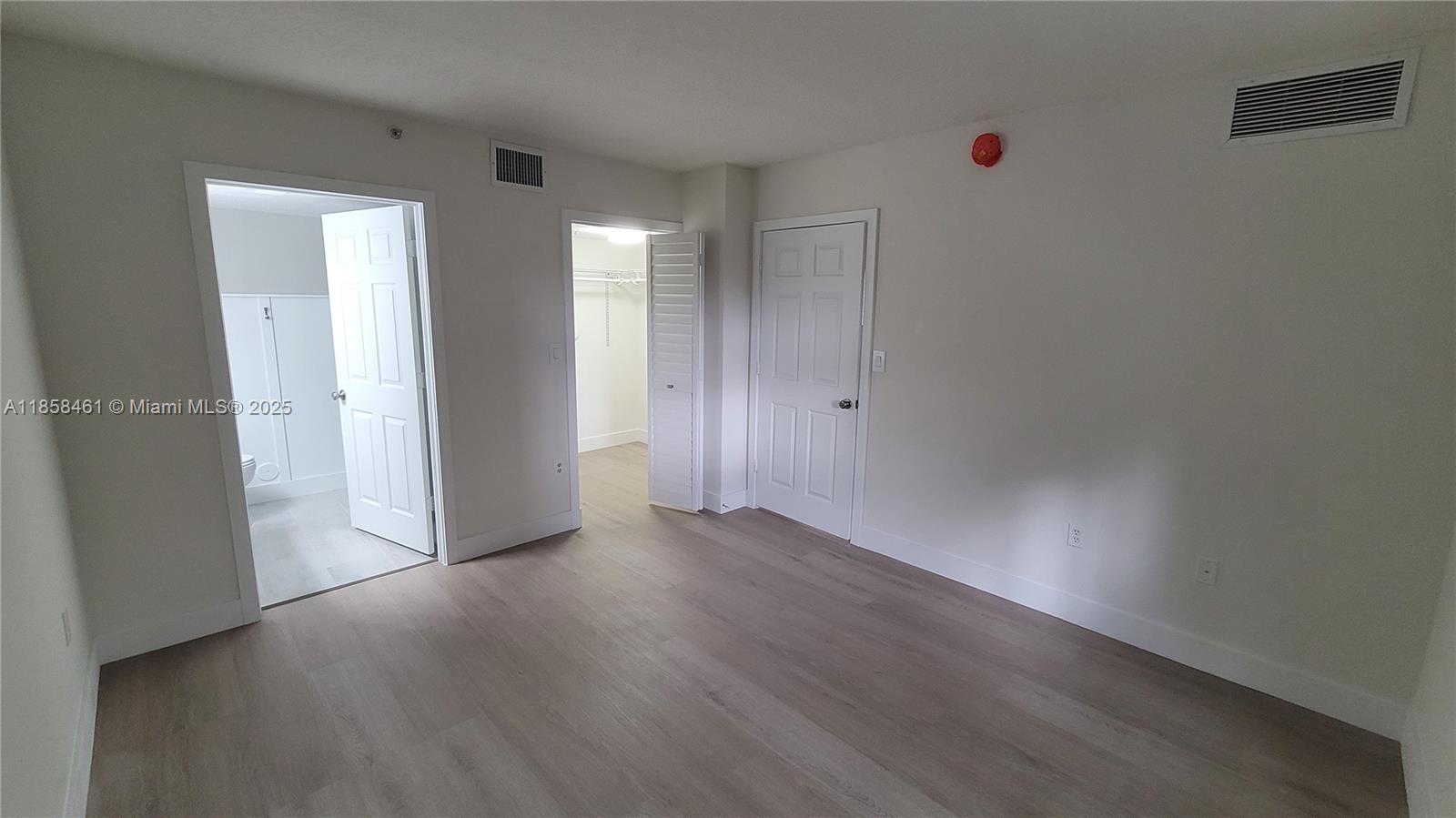 22731 Southwest 88th Place, Unit 101 Cutler Bay, FL 33190 - Photo 23 of 59 an empty room with wooden floor and windows