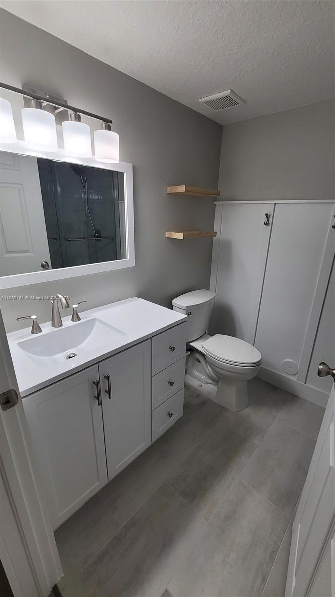 22731 Southwest 88th Place, Unit 101 Cutler Bay, FL 33190 - Photo 26 of 59 a bathroom with a double vanity sink and mirror