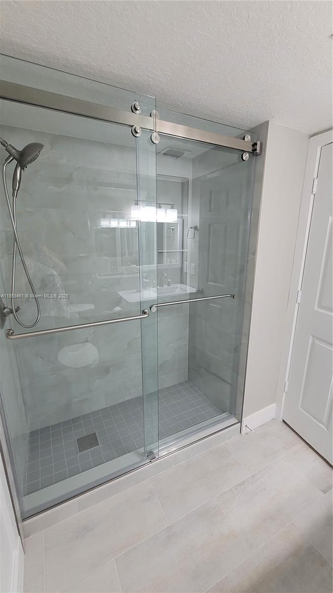 22731 Southwest 88th Place, Unit 101 Cutler Bay, FL 33190 - Photo 28 of 59 a bathroom with a glass shower door