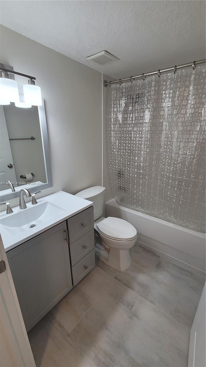 22731 Southwest 88th Place, Unit 101 Cutler Bay, FL 33190 - Photo 37 of 59 a bathroom with a double vanity sink toilet and shower