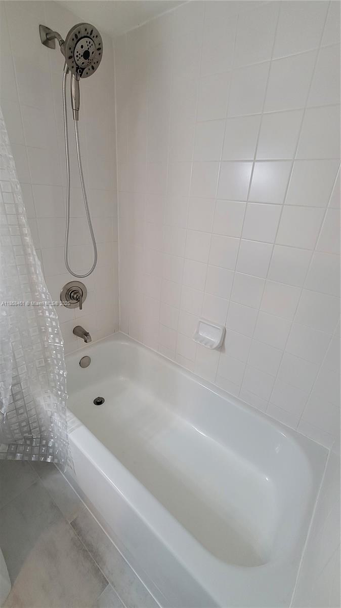 22731 Southwest 88th Place, Unit 101 Cutler Bay, FL 33190 - Photo 38 of 59 a bathroom with a bath tub with a shower