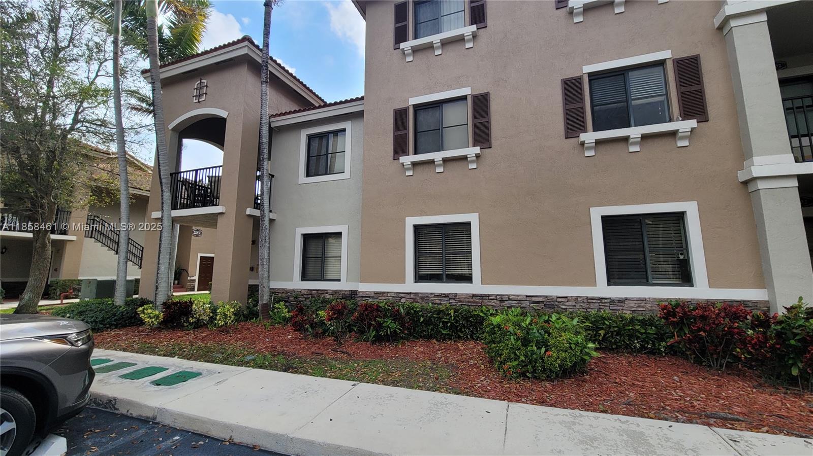 22731 Southwest 88th Place, Unit 101 Cutler Bay, FL 33190 - Photo 42 of 59 a front view of a house with yard and parking