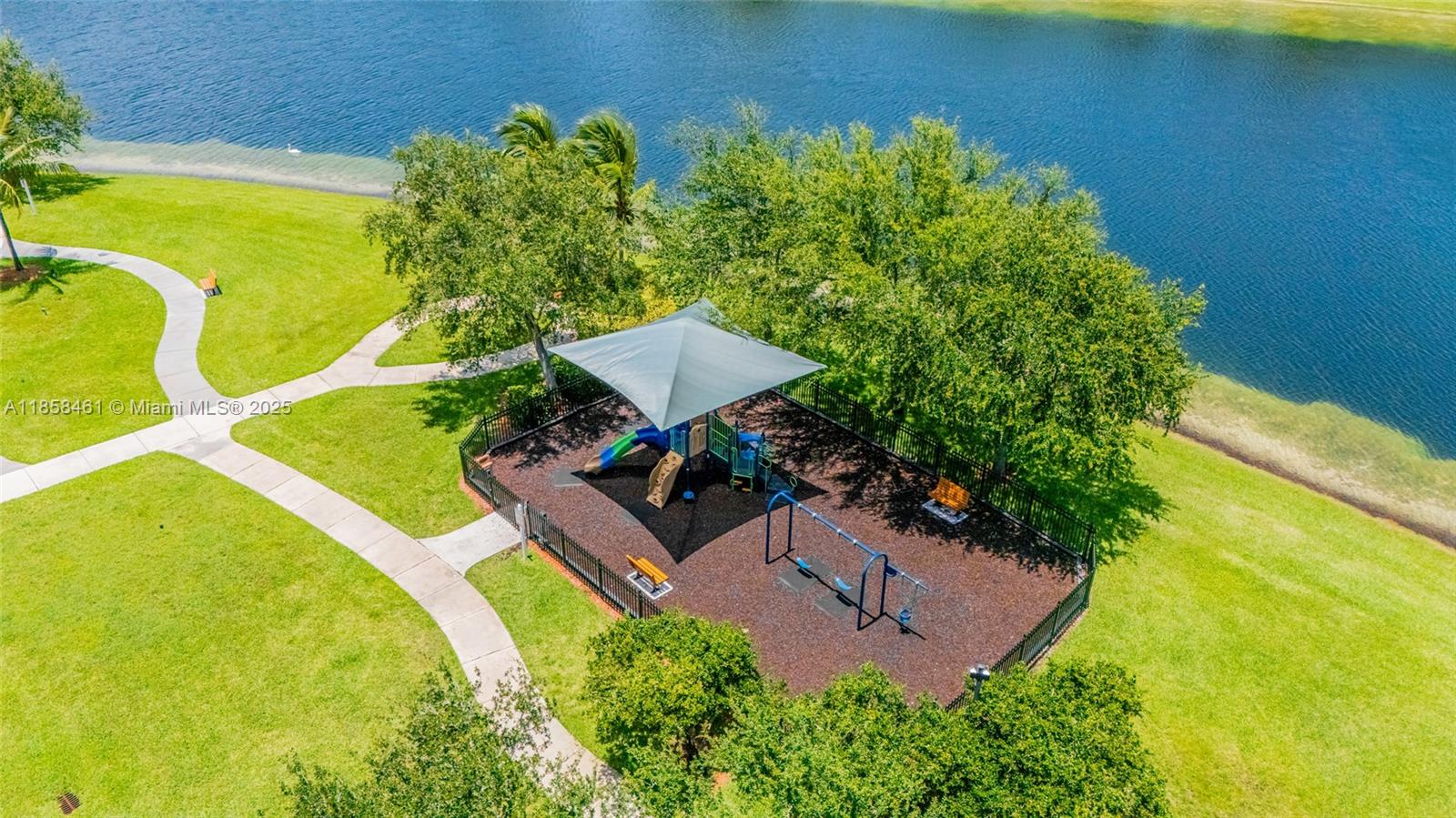 22731 Southwest 88th Place, Unit 101 Cutler Bay, FL 33190 - Photo 50 of 59 a view of a backyard with plants and a lake view