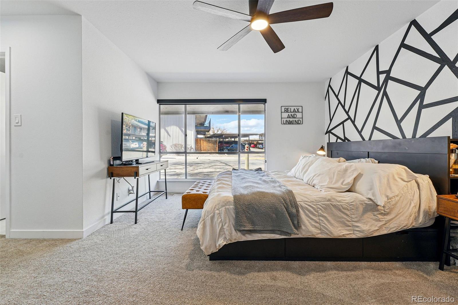 6495 East Happy Canyon Road, Unit 62 Denver, CO 80237 - Photo 12 of 23 a bedroom with a bed and a chandelier