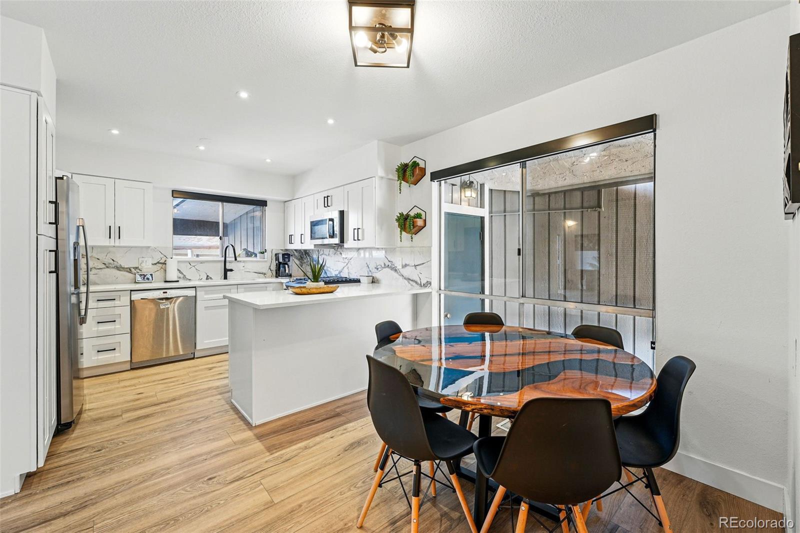 6495 East Happy Canyon Road, Unit 62 Denver, CO 80237 - Photo 4 of 23 a kitchen with a table chairs refrigerator and cabinets