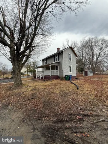 a white house that has a tree in front of it