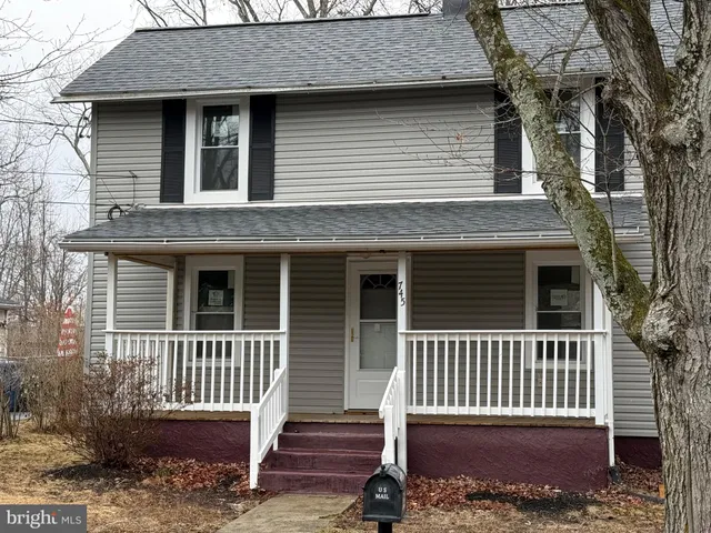 a view of a house with a bench and wooden fence