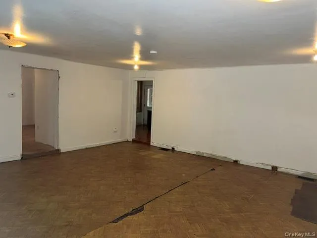an empty room with a chandelier fan