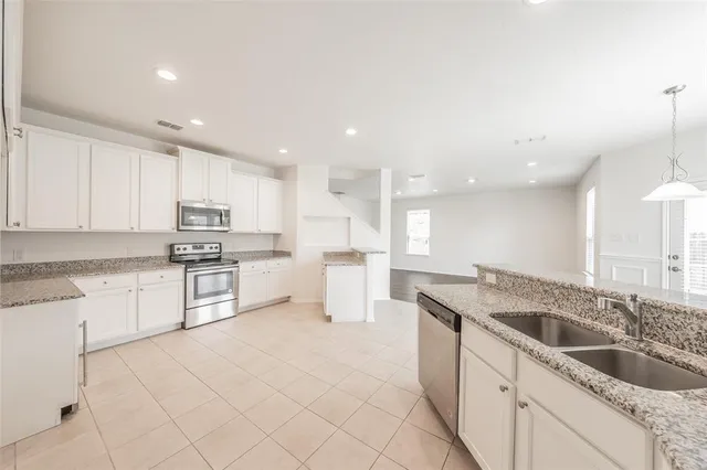 a kitchen with granite countertop white cabinets and white appliances