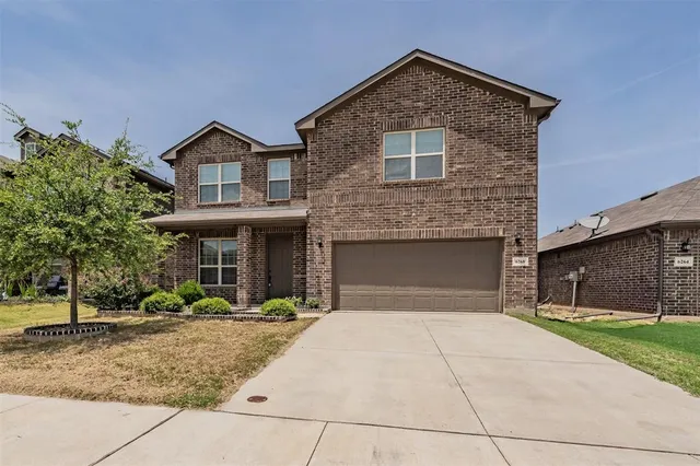 a front view of a house with yard and trees
