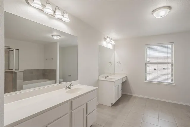 a bathroom with a sink a large mirror and shower