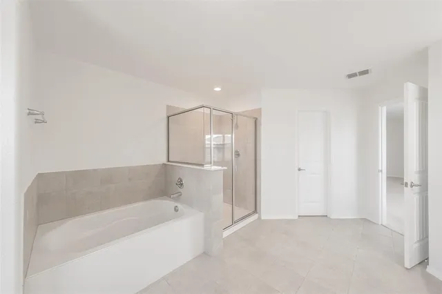 a spacious bathroom with a bathtub and shower