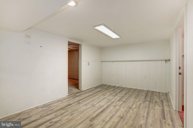 an empty room with wooden floor and natural light