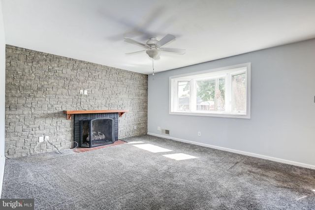an empty room with windows and fireplace