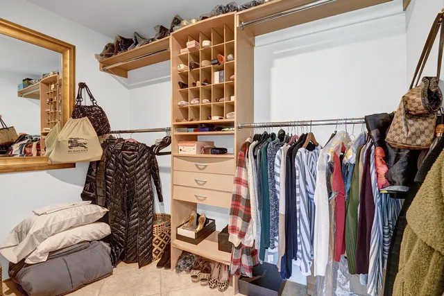 a view of walk in closet with clothes and shoes