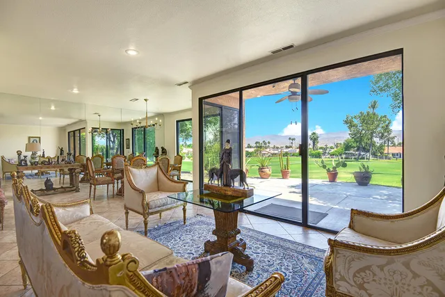 a living room with couches a coffee table and chairs with outer view