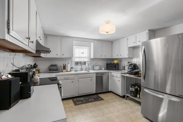 a kitchen with stainless steel appliances white cabinets and wooden floors
