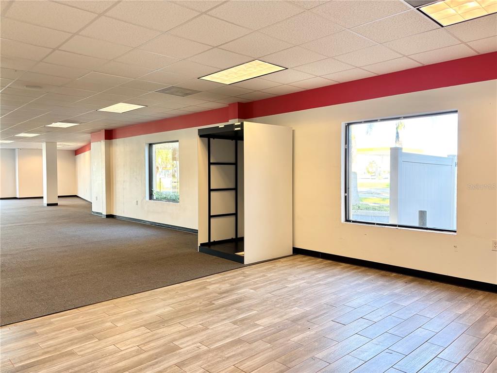 2672 Tamiami Trail, Unit 6B 7B Port Charlotte, FL 33952 - Photo 11 of 36 a view of an empty room with a window and wooden floor