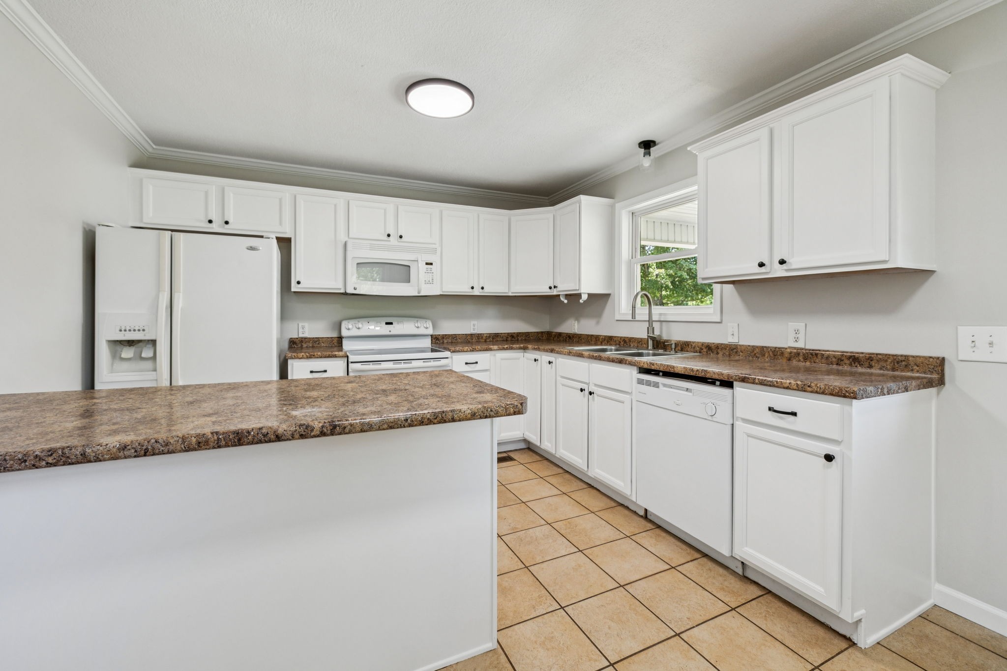 2585 Pow Road Baxter, TN 38544 - Photo 23 of 83 a kitchen with granite countertop a sink stainless steel appliances white cabinets and a window