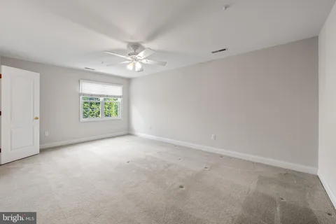 an empty room with a window and a ceiling fan