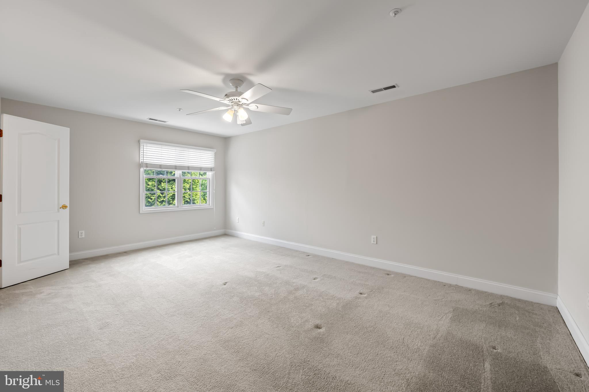 24 Roland Green, Unit 12 Baltimore, MD 21210 - Photo 30 of 53 an empty room with a window and a ceiling fan