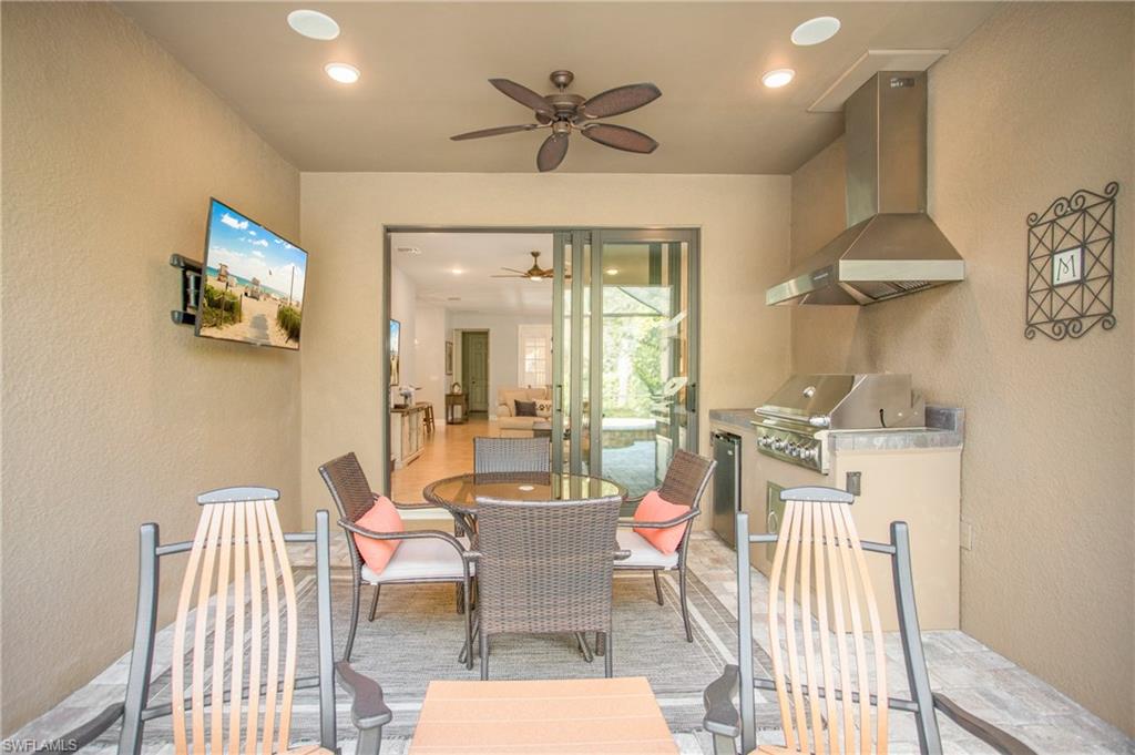 7674 Jacaranda Lane Naples, FL 34114 - Photo 21 of 45 a dining room with furniture a rug and wooden floor