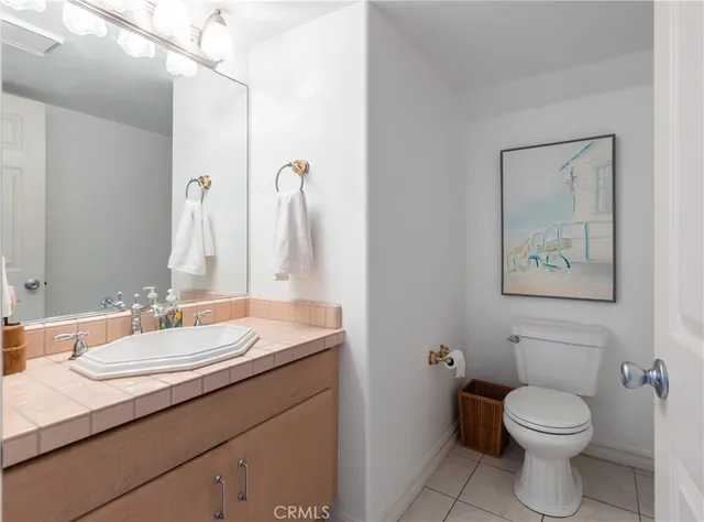 a bathroom with a granite countertop toilet sink and mirror
