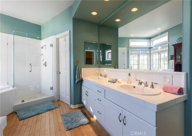 a bathroom with a double vanity sink mirror and shower