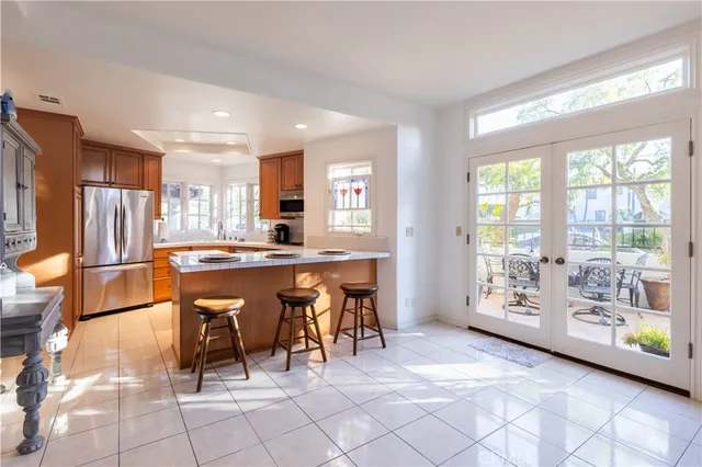 a dining room with stainless steel appliances a table chairs and a large window