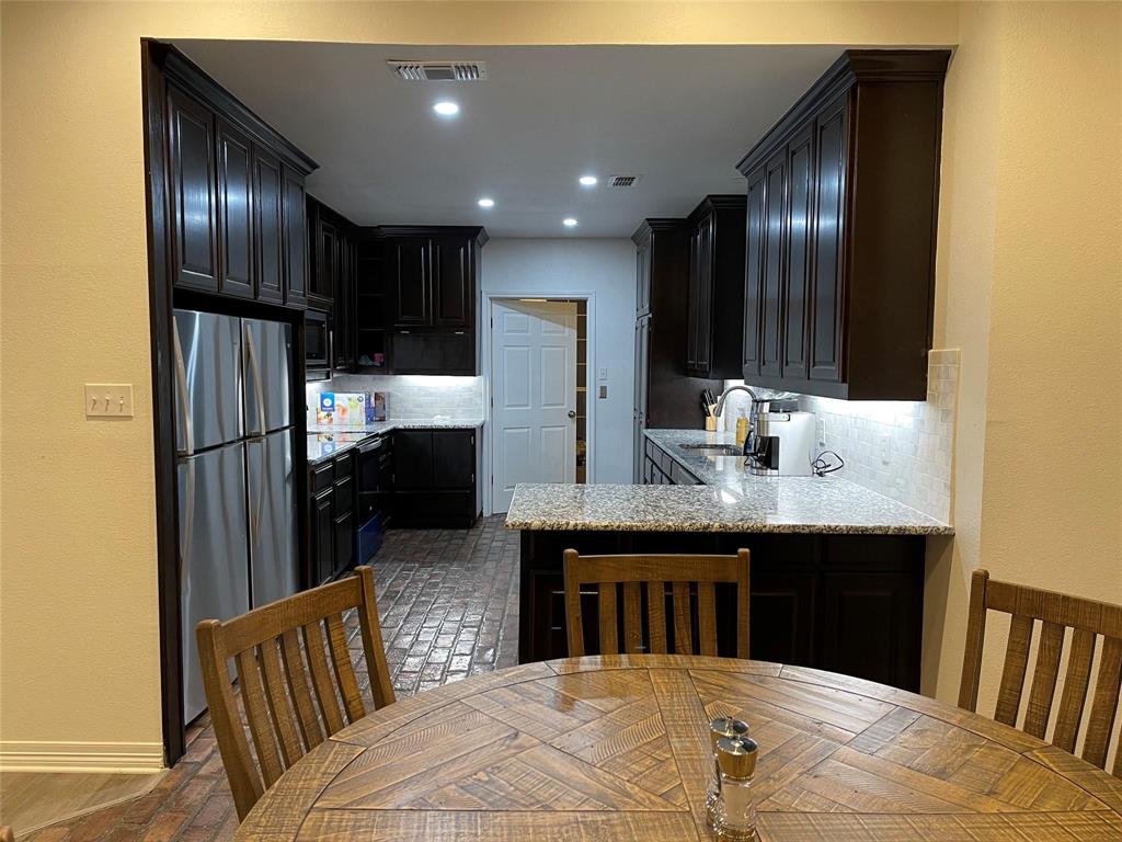 865 Higgins Road Sherman, TX 75092 - Photo 13 of 40 a kitchen with stainless steel appliances granite countertop a sink refrigerator and cabinets