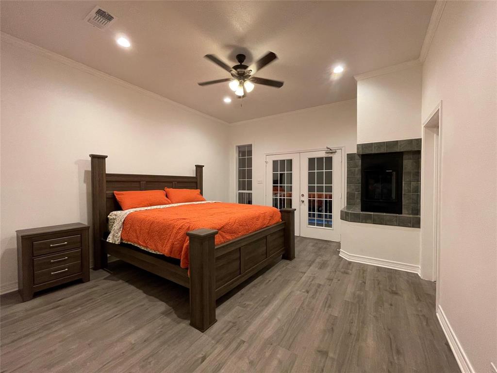 865 Higgins Road Sherman, TX 75092 - Photo 19 of 40 a bedroom with a large bed and a tv