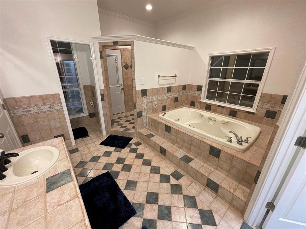 865 Higgins Road Sherman, TX 75092 - Photo 21 of 40 a bathroom with a sink a toilet a mirror and shower