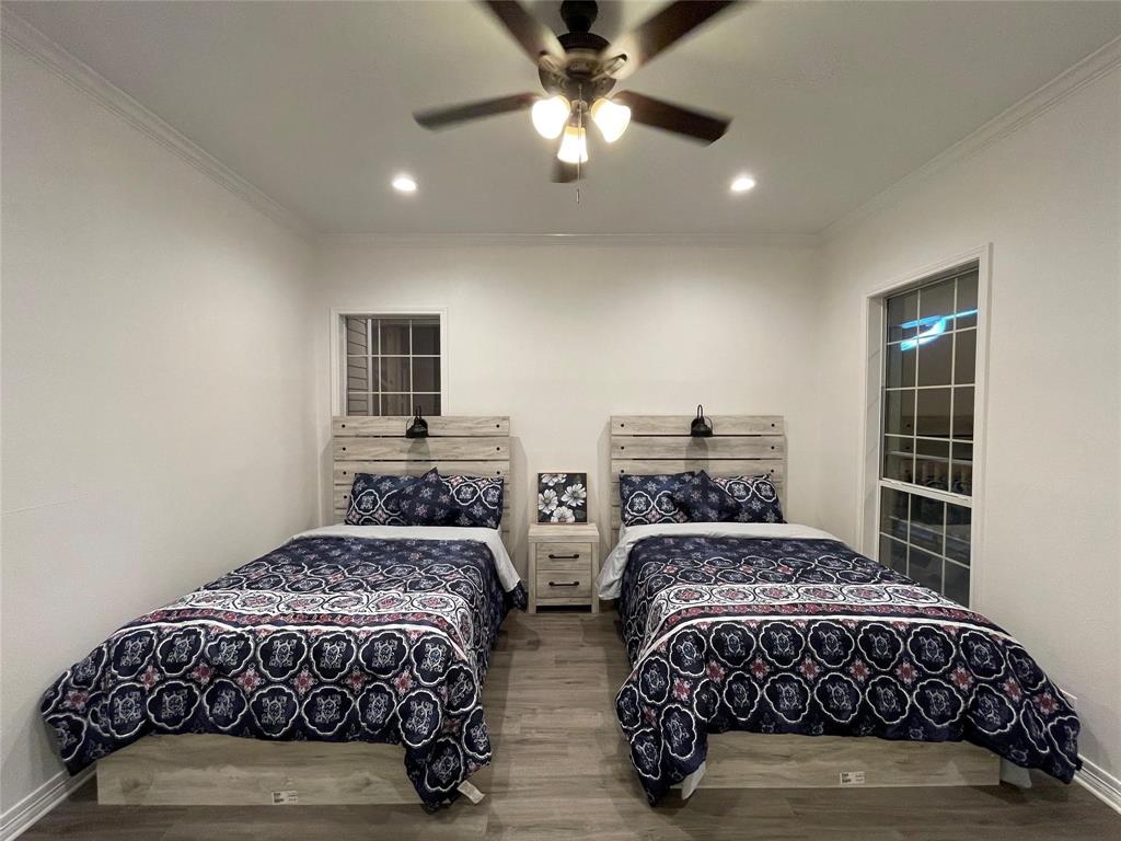 865 Higgins Road Sherman, TX 75092 - Photo 25 of 40 a bedroom with two beds and painting on the wall