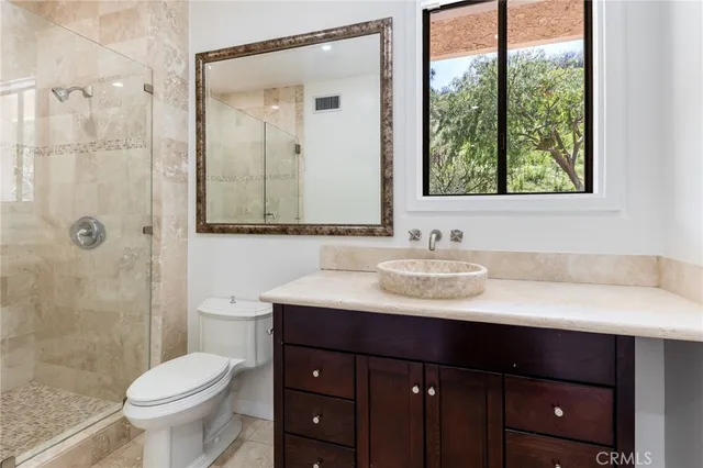 a bathroom with a sink vanity mirror and toilet