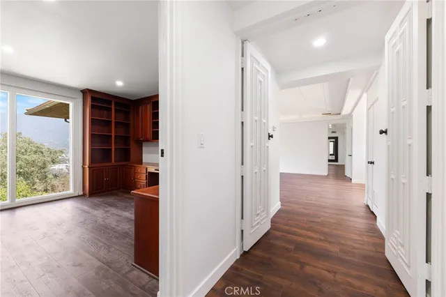 a view of a hallway with wooden floor and closet