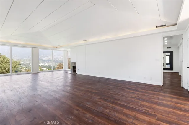a view of a room with wooden floor and a window