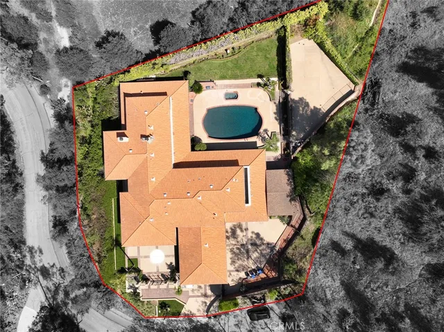 an aerial view of a house with a yard and wooden fence