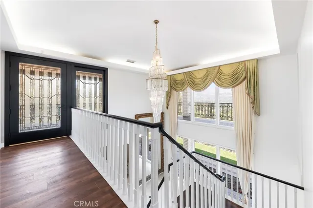 a view of a hallway to an entryway with wooden floor