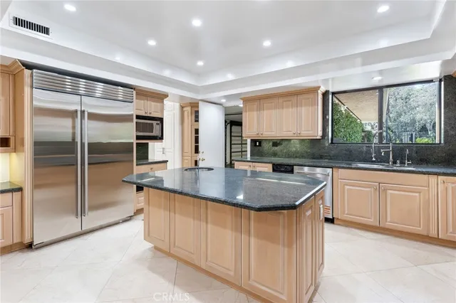 a kitchen with stainless steel appliances granite countertop a sink and a large window