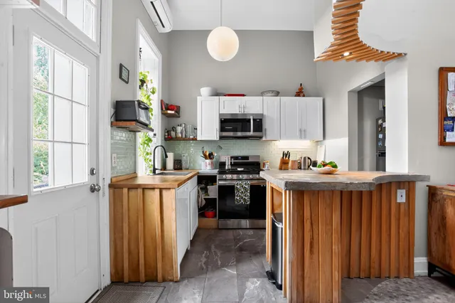 a kitchen with kitchen island granite countertop a stove and a sink