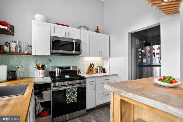 a kitchen with stainless steel appliances granite countertop a stove a microwave and cabinets